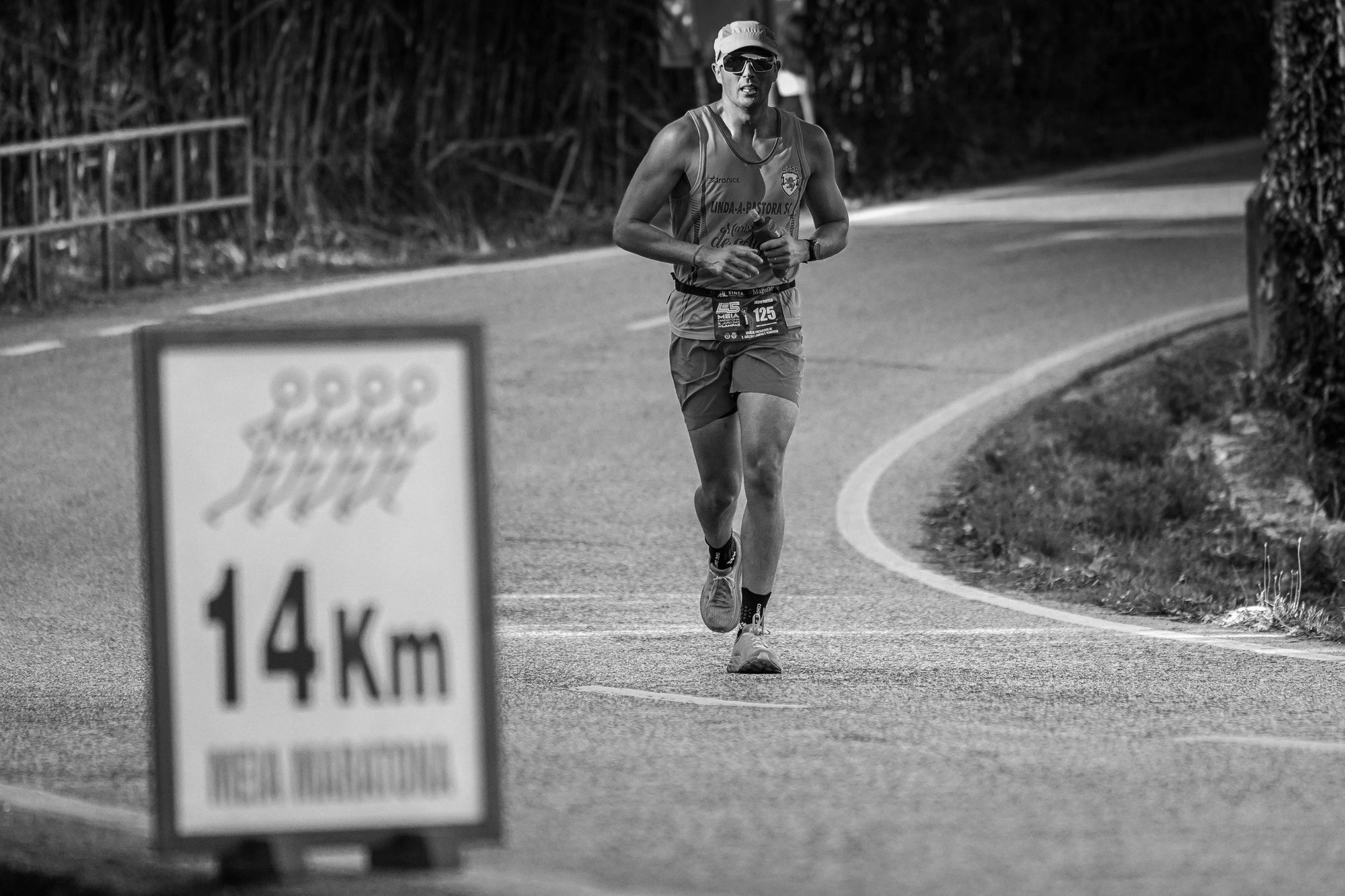 Runner mid-stride during a half marathon passing a 14 km marker — symbolizing Money-Lead’s focus on endurance, discipline, and measurable financial progress toward long-term goals.